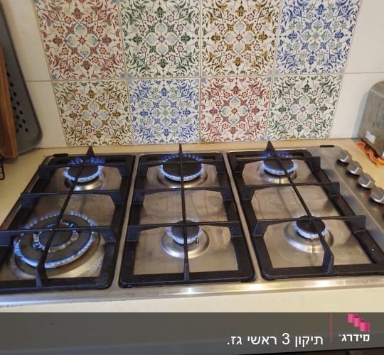 כיריים גז עם להבות דולקות על משטח מטבח